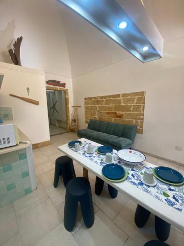 een woonkamer met een tafel en blauwe krukken bij La Casa dei Venti in Gallipoli