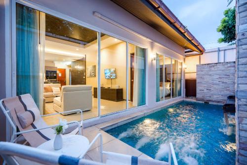 a swimming pool in the backyard of a house at The Ville Jomtien- 3 Bedrooms Deluxe Pool Villa in Jomtien Beach