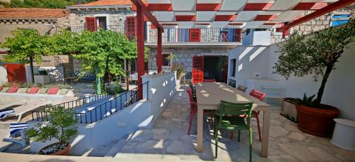 an outdoor patio with a table and chairs and trees at Villa Smoquizza in Smokvica