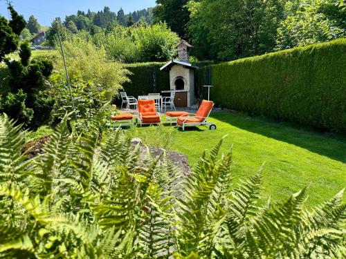 a garden with orange chairs and a table and chairs at Chlösterli in Luzern