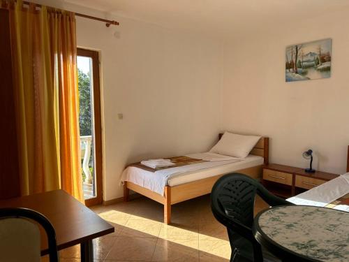 a bedroom with a bed and a table and a window at Apartment Put Vidaka in Poličnik