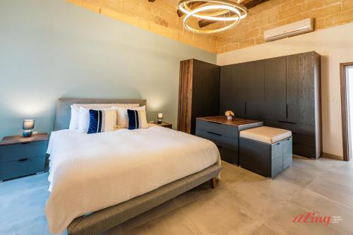 Un dormitorio con una cama grande y una mesita de noche. en Stylish Malta Family Retreat with Kids Room & Gym, en Żejtun