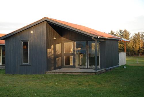 a small black house with a large window at Hytteby – Hanstholm Camping – Thy Feriepark in Hanstholm