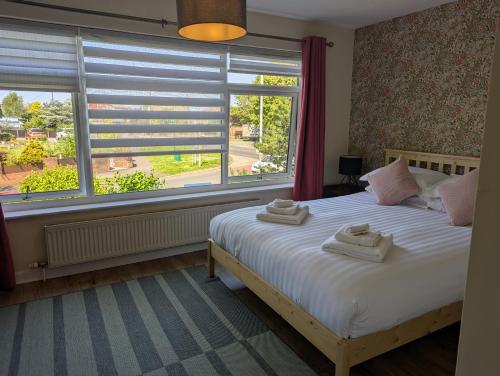 a bedroom with a bed and a large window at Highcross Corner in Poulton le Fylde