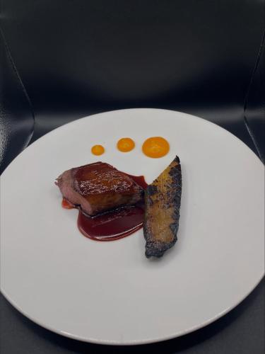 a plate of food with meat and eggs on it at Manoir de Kerhuel de Quimper in Plonéour-Lanvern