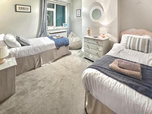 a bedroom with two beds and a mirror at Number Five in Filey