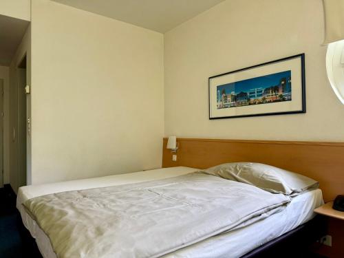 a bed in a bedroom with a picture on the wall at Hotel Restaurant Florida in Studen