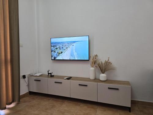 a living room with a tv on a white wall at Odi Apartments in Durrës