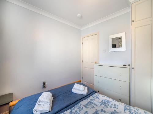 a bedroom with a blue bed and a dresser at Bowness Oaks in Bowness-on-Windermere
