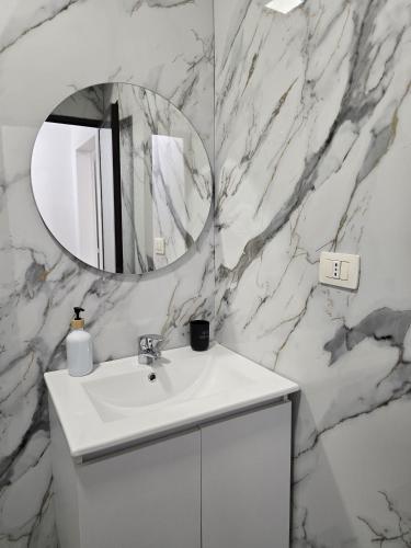 a bathroom with a white sink and a mirror at Odi Apartments in Durrës