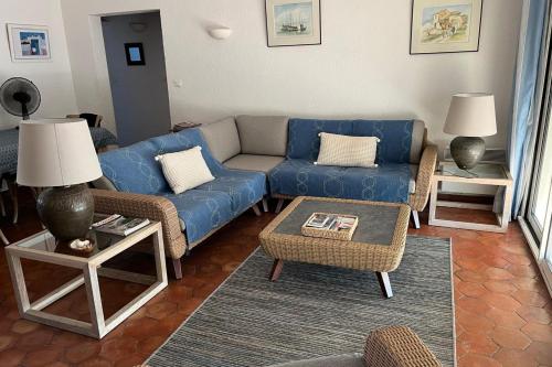 un salon avec un canapé bleu et des chaises dans l'établissement La Terrasse de Port Grimaud - Welkeys, à Grimaud