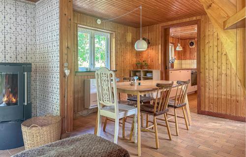 a dining room with a table and chairs and a fireplace at Amazing Home In Aakirkeby With Wifi in Vester Sømarken