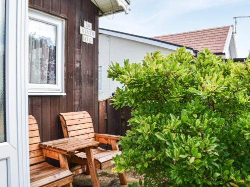 a wooden bench sitting on the porch of a house at Enjoy Your Stay Cottage in Bessingby