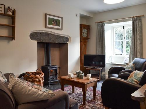 a living room with a wood stove in a living room at Coopers Cottage in Haverthwaite
