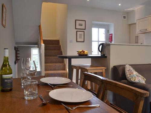 a dining room table with a bottle of wine on it at Coopers Cottage in Haverthwaite