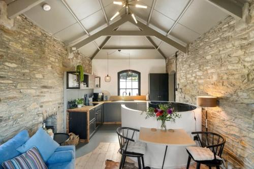 a kitchen and living room with a stone wall at Castle by the Beach with Sea Views Portreath in Redruth