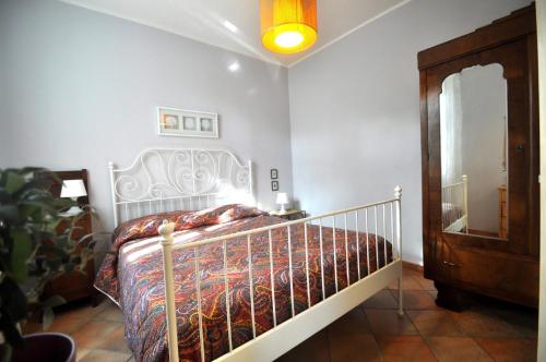Schlafzimmer mit einem Bett mit einem schmiedeeisernen Kopfteil in der Unterkunft La Casa Blu in Mirabella Imbaccari