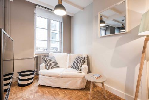 - un salon avec un canapé blanc et un miroir dans l'établissement DIFY Studio - Perrache Confluence, à Lyon