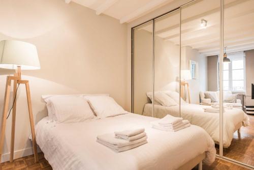 une chambre avec deux lits et un miroir dans l'établissement DIFY Studio - Perrache Confluence, à Lyon