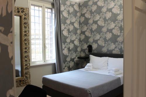a bedroom with a bed and a mirror at Rooms Piramide 1 in Rome