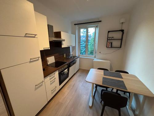 a kitchen with a table and a refrigerator and a table and chairs at City Apartment 8 JOSEF 3rd Floor 44 m2 in Graz