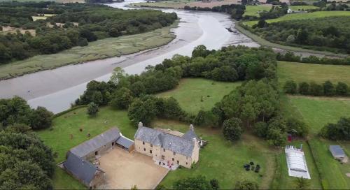 - une vue aérienne sur une vieille maison à côté d'une rivière dans l'établissement La Chambre du Manoir, à La Roche-Derrien
