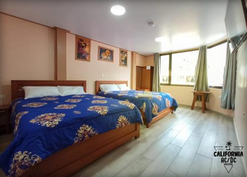 a bedroom with two beds and a window at Hostal California AC-DC in Baños