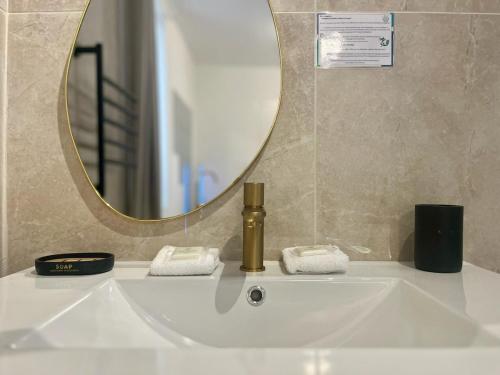 a bathroom sink with a mirror and a soap dispenser at "Pandora" Studio Romantique, Baignoire,Clim, Wifi in Sète