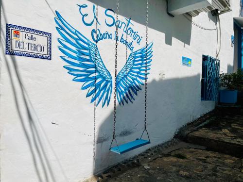 a wall with a painting of a blue bird painted on it at Amanecer Santorini in Estación El Salto