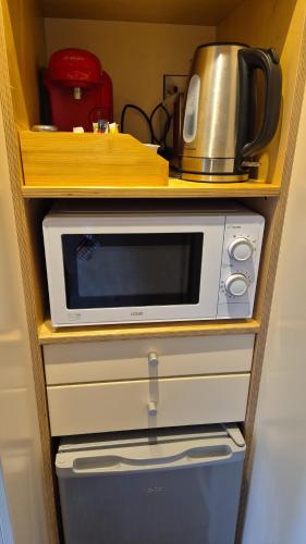 BallintleaにあるForth Mountain Glampingのキッチンカウンターの上に置かれた電子レンジ