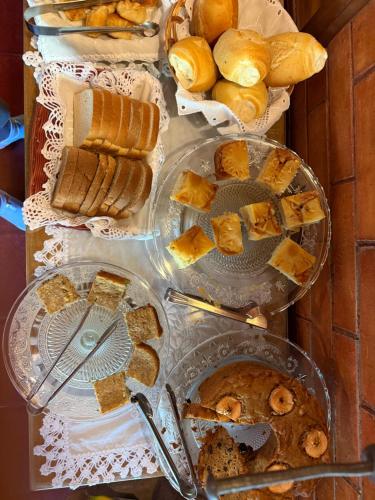 a table topped with different types of bread and pastries at Pousada Penedo in Penedo