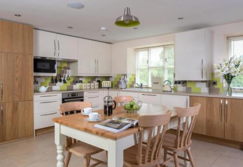 a kitchen with a wooden table and chairs at 2 Bed House - Sleeps 4 - Fishing - Parking - Patio in Abergavenny