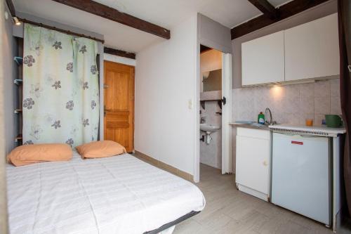 une petite chambre avec un lit et une cuisine dans l'établissement Les Jeux de Boules 6, au Pradet