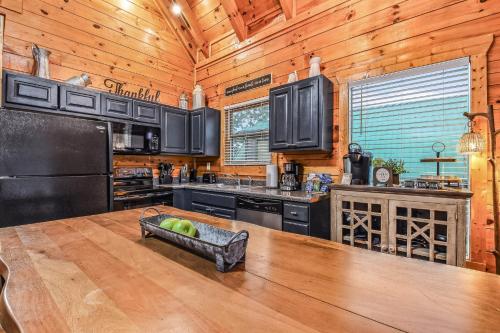 a kitchen with wooden walls and a large wooden table at Grand Mountain View Lodge By Ghosal Luxury Lodging in Sevierville