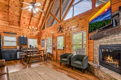 a living room with a fireplace in a log cabin at Grand Mountain View Lodge By Ghosal Luxury Lodging in Sevierville