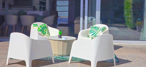 a group of white chairs and a table with a plant at Segolene Design in Albufeira