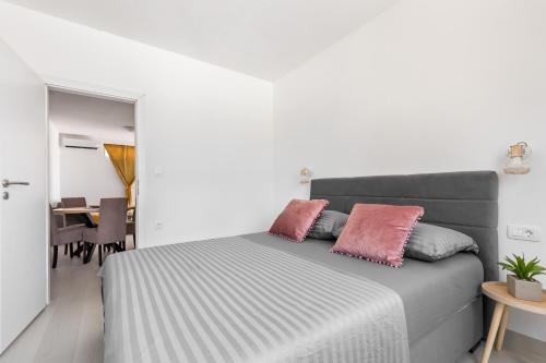 a bedroom with a bed with two pink pillows at Ciovo sunni apartment in Trogir