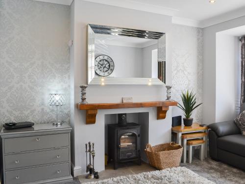 a living room with a fireplace and a mirror at Lowey's Harbour Cottage in Bridlington