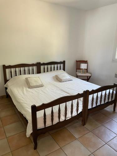 - une chambre avec un grand lit et un cadre en bois dans l'établissement Hébergement à la campagne, à Évenos