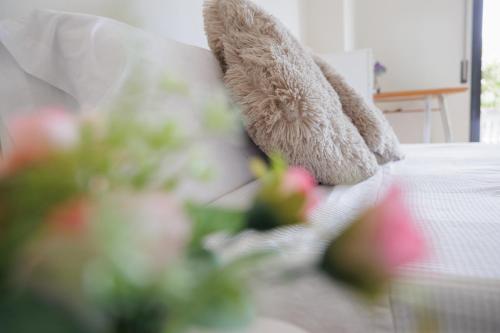 a stuffed teddy bear sitting on a couch with flowers at CIM Apartments in Olivella