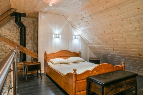 a bedroom with a wooden bed in a attic at Le Portougais, Chalet À Chanaz in Chanaz