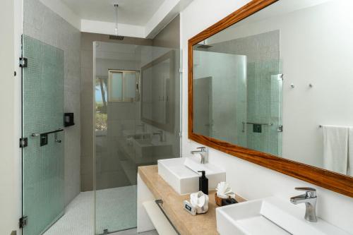 a bathroom with two sinks and a mirror at Hotel La Casa Cielo solo adultos in El Cuyo