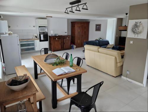 une cuisine et un salon avec une table et des chaises dans l'établissement Au Mont D'en Face - Les Hortensias, à Roz-sur-Couesnon