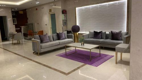 a living room with couches and a coffee table at شقق البيلسان الذهبي للشقق المخدومة - اقتصادي in Quai