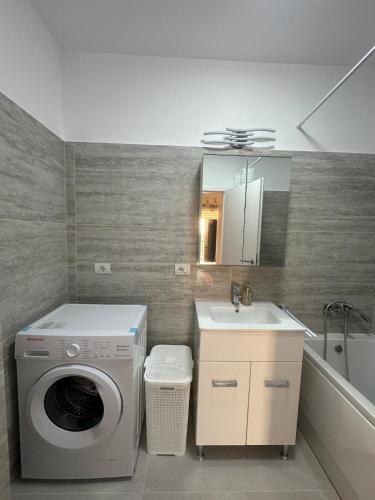 a bathroom with a washing machine and a sink at Suba's Apartment Free Parking Self Check-in in Timişoara