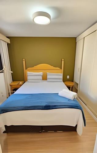 a bedroom with a large bed with a blue blanket at Flat Apart-Hotel com dois quartos e dois banheiros uh127 in Sao Paulo
