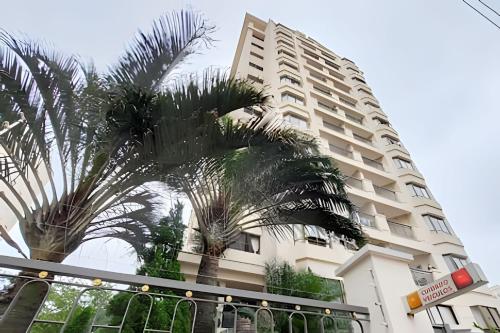 a tall building with palm trees in front of it at Flat Apart-Hotel com dois quartos e dois banheiros uh127 in Sao Paulo