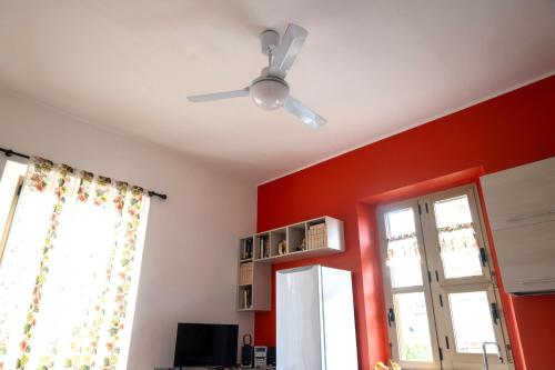 a ceiling fan in a room with a red wall at Tra mare e monti in Chieti