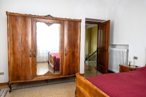 a bedroom with a large wooden cabinet with a mirror at Tra mare e monti in Chieti