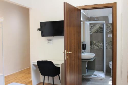a bathroom with a sink and a desk with a chair at Rooms Piramide 1 in Rome